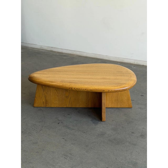 W47 D32 H16.5 This contemporary coffee table in solid oak was lightly refinished. It has an architectural tear drop shape...