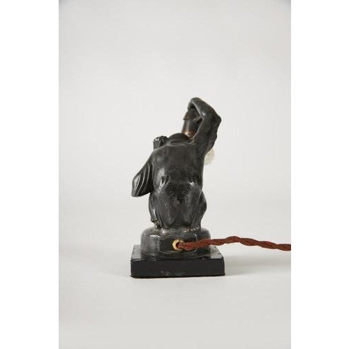 Cast metal sculptural lamp with a glass shade, marble base, and engraved signature on the base. Manufactured by max le...