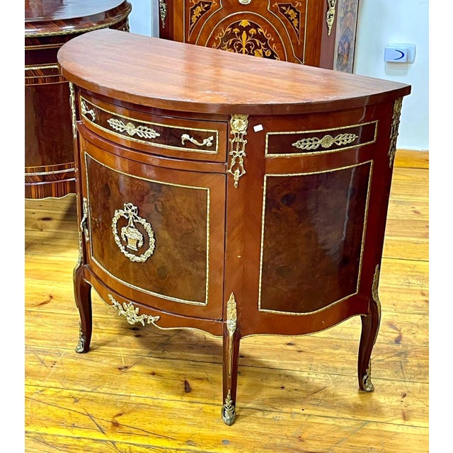 Bring timeless French elegance into your home with this magnificent Louis XVI-style demilune sideboard cabinet. Crafted...