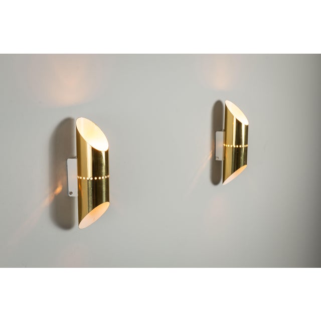 This pair of vintage wall lamps features an elegant brass design with a distinctive cylindrical shade. Each cylinder is...