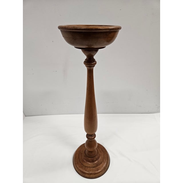 This antique wooden candle stand is approximately 25.75 inches tall, tall enough to be used as a floor stand if desired....