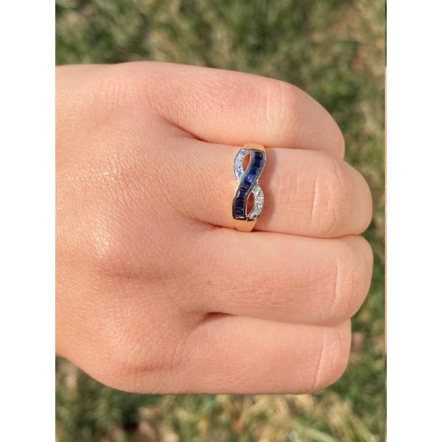 The Lobelville: Ladies Yellow Gold Diamond and Sapphire Crossover Ring. Crafted in trendy yellow gold, this ladies ring...