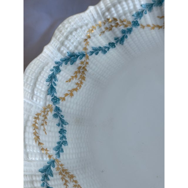 Giraud Limoges Sauviat 1836 service, in white porcelain featuring scalloped edges and a gold and blue floral detail that...