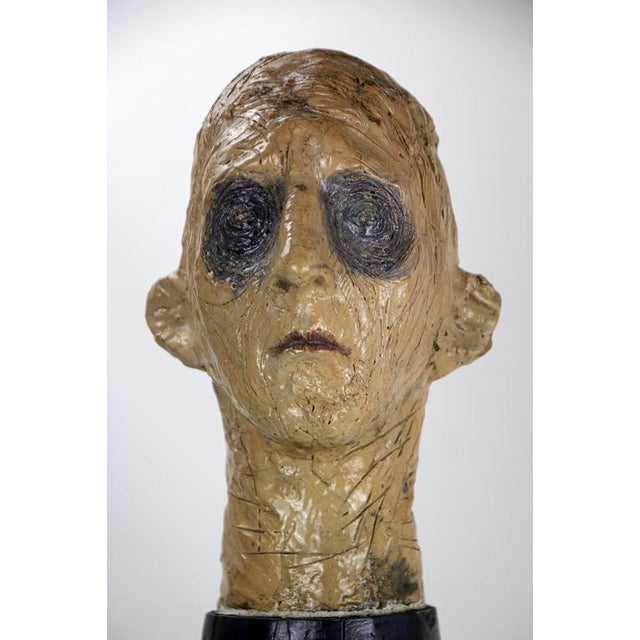 Figurative mixed media sculpture combining raku-fired ceramic and carved black poplar wood with oil polychromy. Created by...