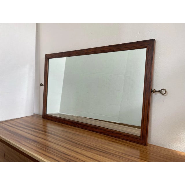 Wall Mirror with Wood Frame, the Frame has Black Colored Accent and Wood Inlays at Each Corner. Brass Toned Hardware....