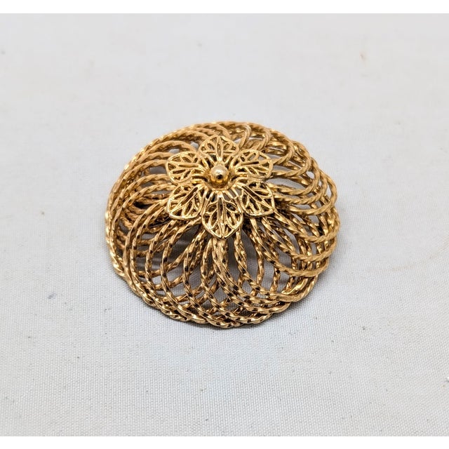 1960s goldtone round domed flower center with wire spiral surround brooch with security clasp. Marked "NAPIER©" on a...
