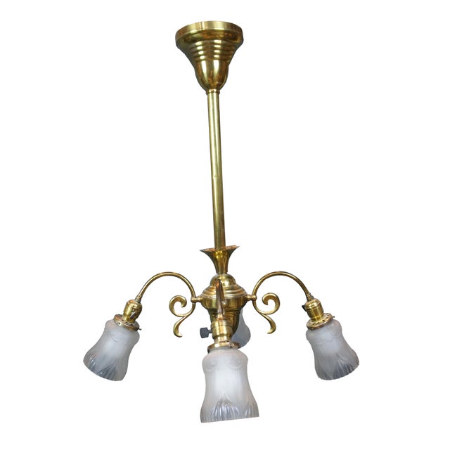 Antique drop light pendant chandelier. Made of brass featuring Victorian styling with four scrolled arms and frosted glass...