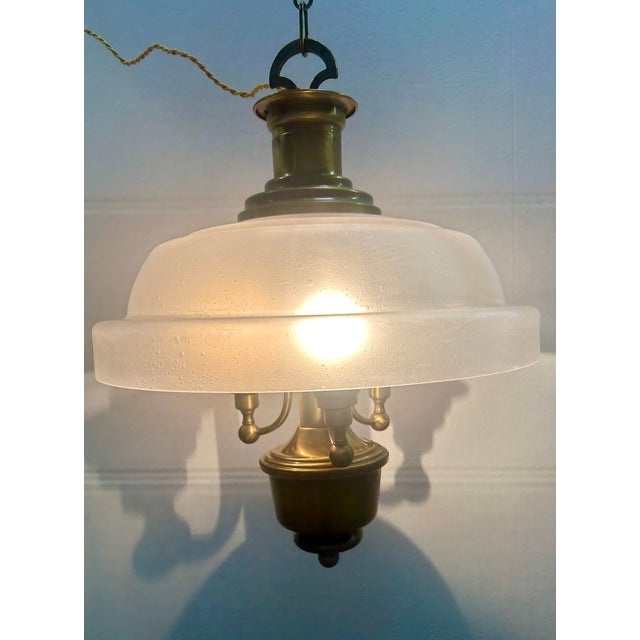 Chandelier made entirely of brass with three E14 lights and white satin glass with a pulegoso effect. Up to 250V...