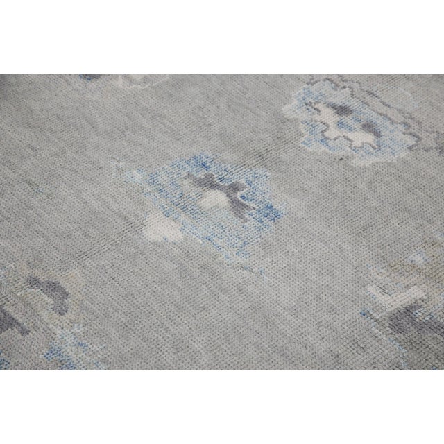 This modern Turkish Oushak rug is a stunning piece of art that has been handwoven using traditional techniques by skilled...