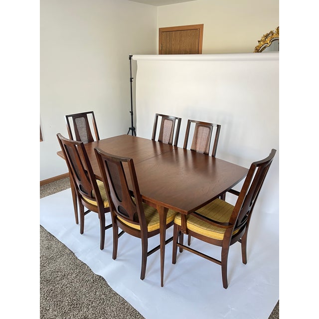 Vintage walnut dining table and six chairs manufactured by Broyhill for the Brasilia collection circa early 1960s. Seldom...