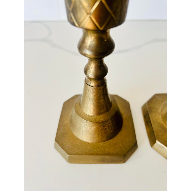 This pair of vintage brass candlesticks feature a distinctive design with an octagonal base and cylindrical body adorned...