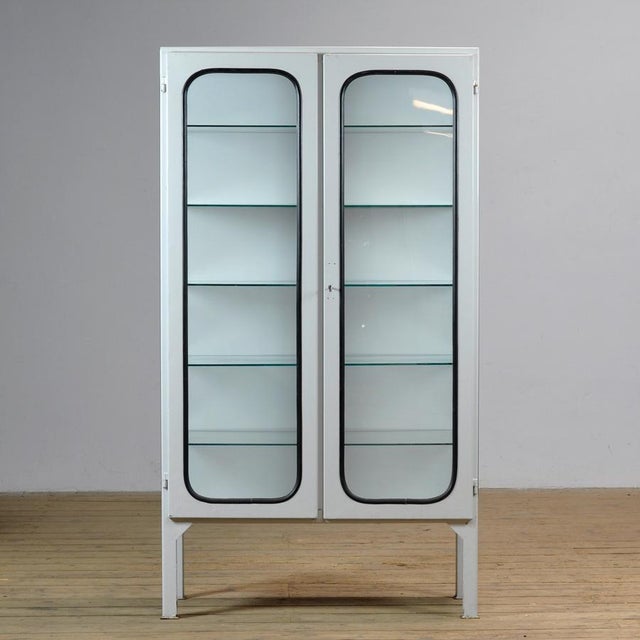 Vintage medical cabinet from the 1970s, made in Hungary. This characterful cabinet is made of iron and glass, with the...