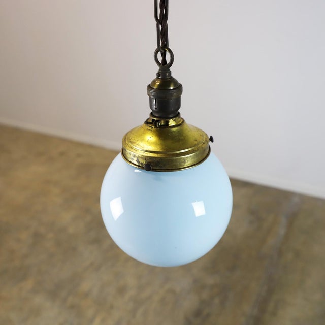 Circa 1930. We offer this Art Deco pendant light made in milk glass circular shade rare blue color. Great patina and...