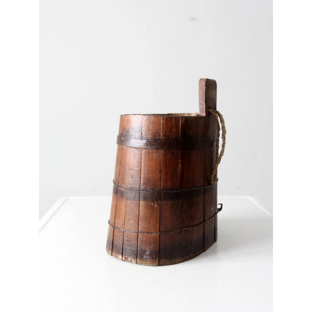 This antique wood stave barrel is a rare find, crafted by hand with a tapered stave construction and wire and iron...