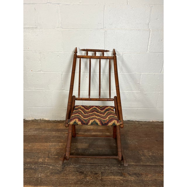 Vintage folding campaign or camp rocking chair. Eastlake style detail with finial tops. Nice flame stitch upholstery....