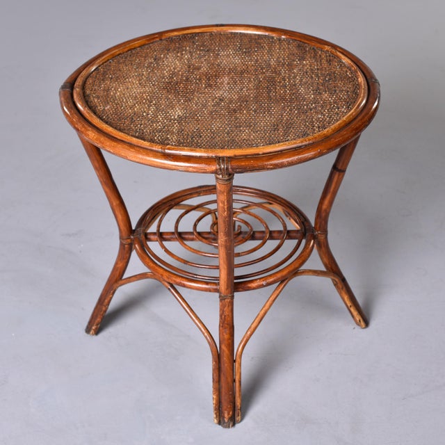 A mid-century side table with a distinct French Riviera aesthetic, circa 1950s. Crafted from honey-toned bent rattan and...
