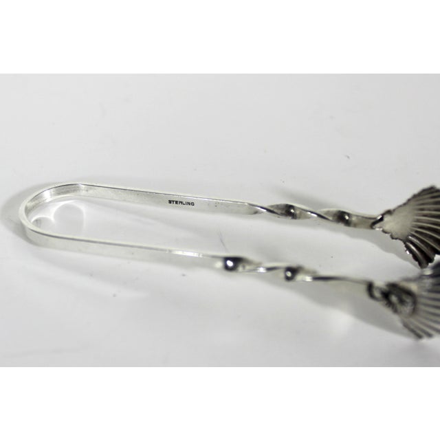 Small vintage sterling silver sugar tongs with shell or leaf tips. Hallmarked: Sterling 3 3/8” long 3/4” wide 3/4” tall