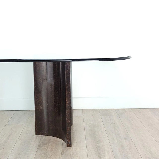 A modern glass top dining table on metallic finished wood pedestals, U.S.A. circa 1970.