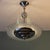 This round Art Deco chandelier, featuring four curved, thin glass strips reminiscent of a comet's tail or a waterfall, is...