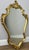 A stunning Vintage French style wall mirror featuring an elegant ornate gold-toned frame with flowing curves and...