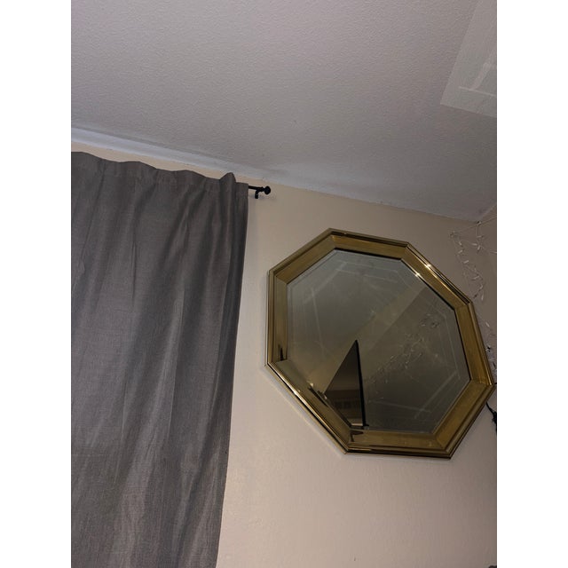 Vintage octagonal wall mirror featuring a solid brass-tone frame and decorative etched glass. The faceted, geometric...