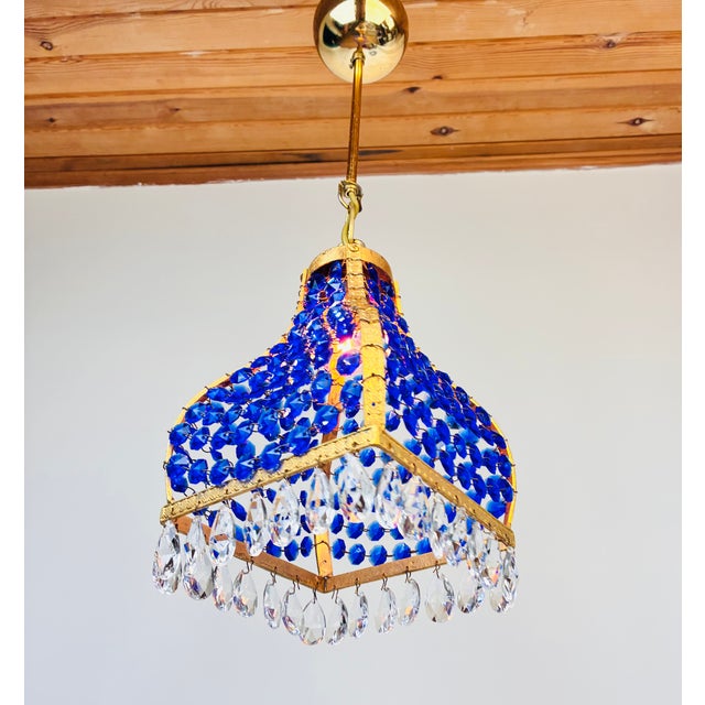 Looking for a unique 1960s vintage pair chandelier? This aqua blue crystal and polished brass pendant light, originally...
