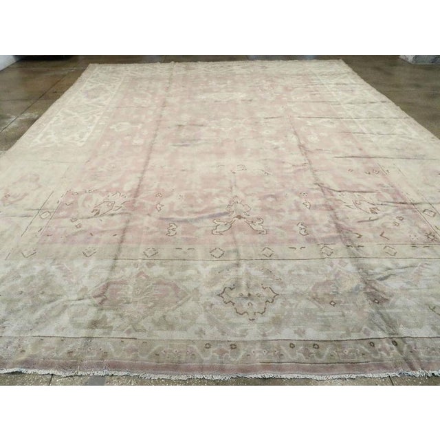 An antique European Oushak large carpet. This boldly drawn western Turkish workshop carpet has a field design including...