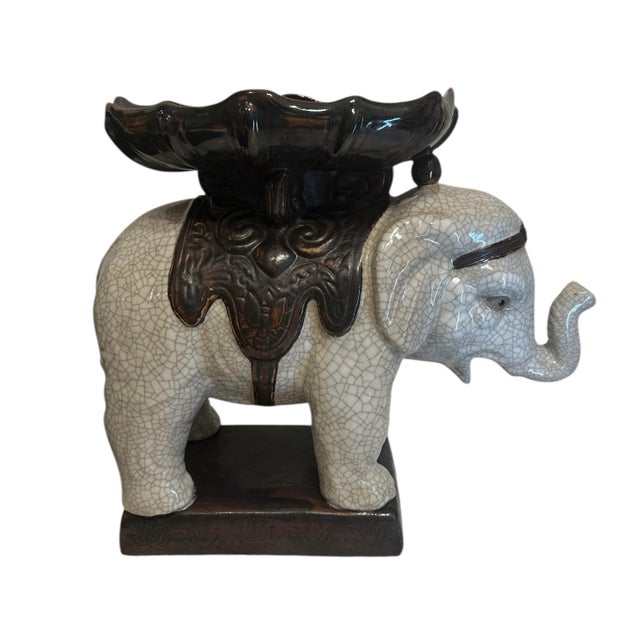 This decorative ceramic elephant plant stand with bowl features an off white crackle-glazed finish elephant figure with an...