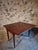 This antique English drop-leaf table, crafted from mahogany, dates to the late 19th century. It features a classic and...