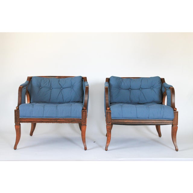 French Louis XVI style lapis blue tub armchairs, circa 1960s. They feature curved wood trimmed low backs, oval cut-out...