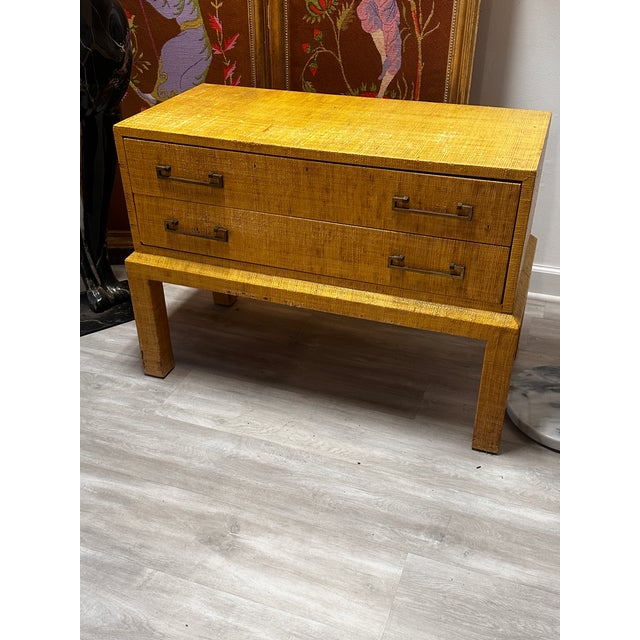Raffia covered two-drawer chest or side table with Ming style brass pulls, as common motif with ‘mastercraft’ furniture....