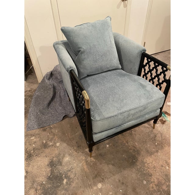 Elegant fabric with exposed wood frame with exposed wood frame, influencing the open fretwork design on each arm panel....