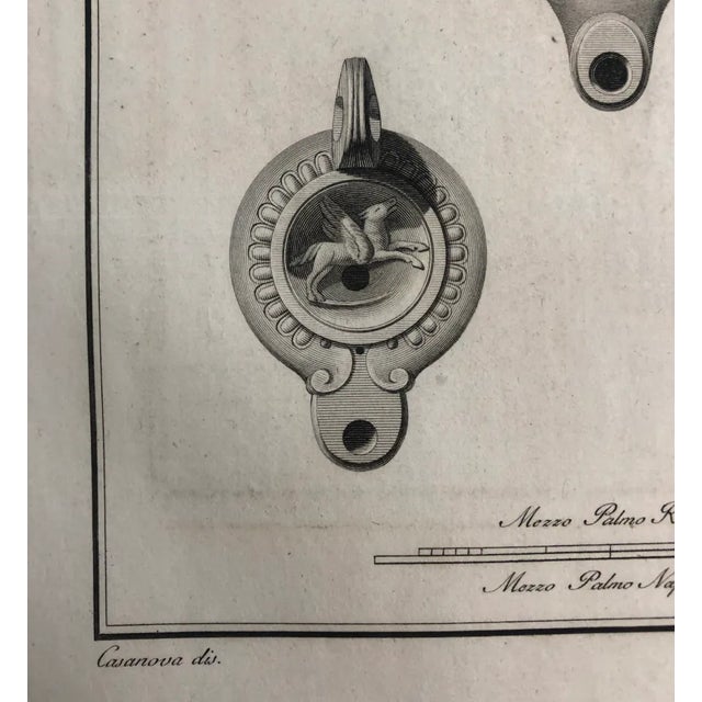 From a group of 18th century engravings of Roman Lamps, each with mythological characters and architectural elements. This...