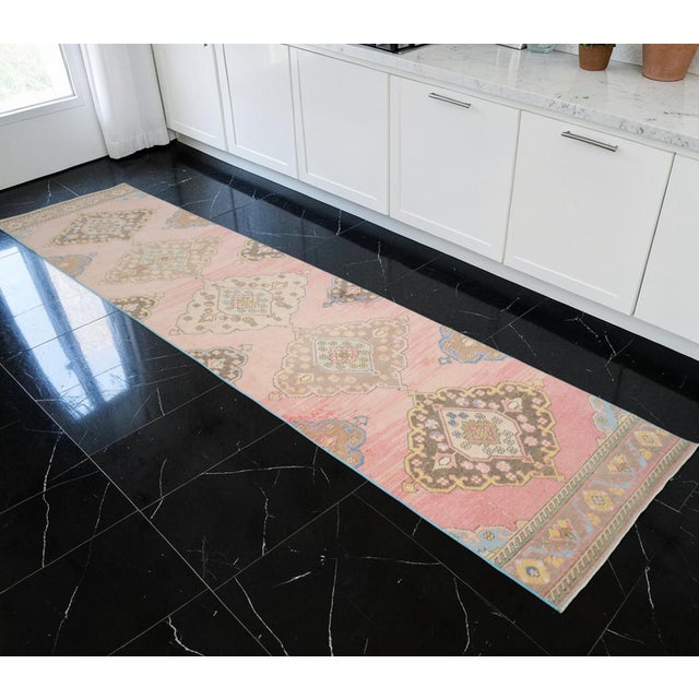 Woven in the celebrated workshops of Oushak during the 1970s, this authentic Turkish runner rug showcases a refined...