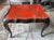 An elegant chinoiserie tray table displaying beautiful colors of ebony and Chinese red with gold filigree accents. Makes...