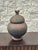 Mid-20th century hand-built terracotta lidded vessel attributed to the Lobi pottery tradition of Burkina Faso. The rounded...