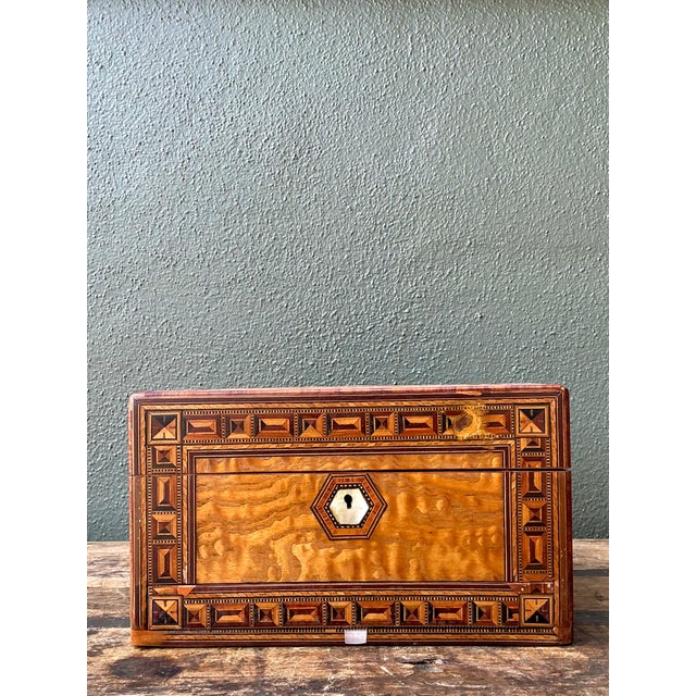 This vintage marquetry inlaid wood box is a beautifully crafted example of fine decorative woodworking, showcasing...