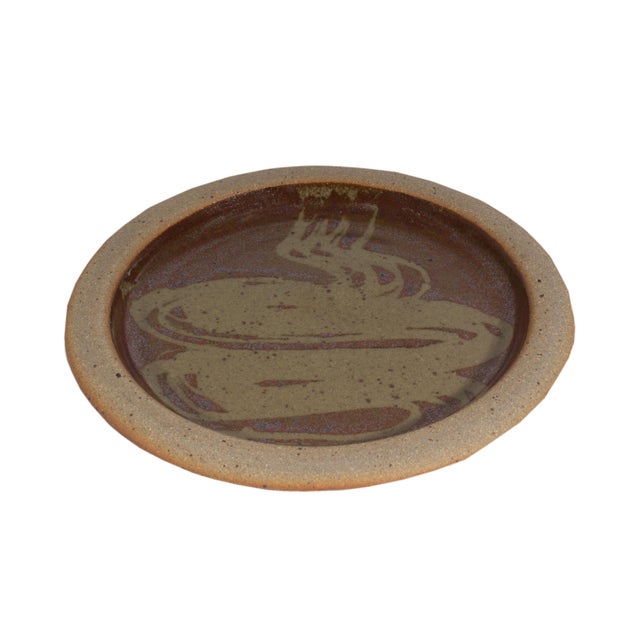A studio pottery dish by Muchelney Pottery. An abstract reddish brown speckled glazed design is depicted upon this round...