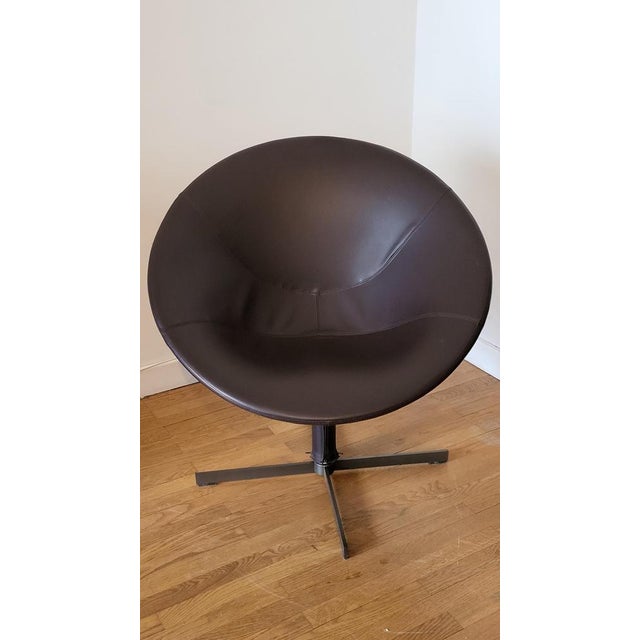 The dark brown leather swivel Hillroad armchair, designed by Christophe Pillet for Zanotta, fits perfectly into a lounge...