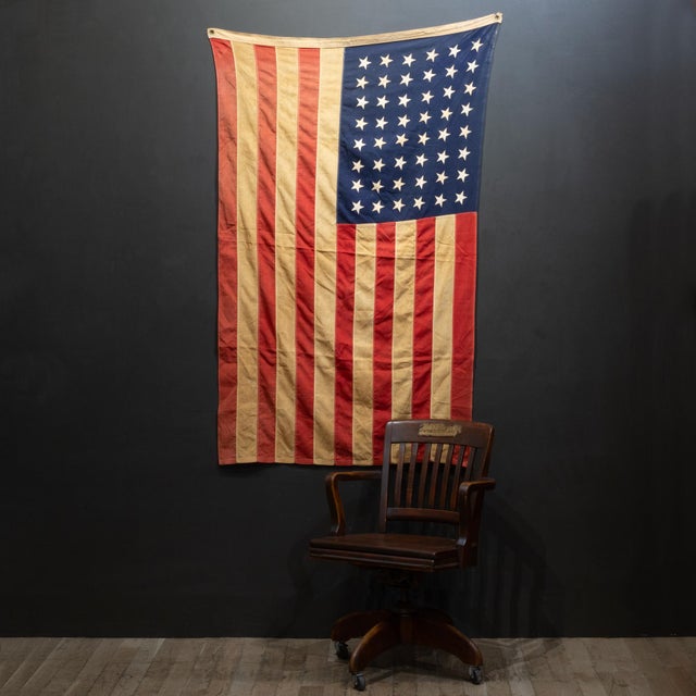 ABOUT An original American flag with 48 sewn stars and stripes and brass grommets. CREATOR Bulldog Bunting. DATE OF...