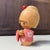 Small and charming vintage sōsaku kokeshi by Ishida Waichi. The wooden doll has a soft, playful presence and wears a pink...