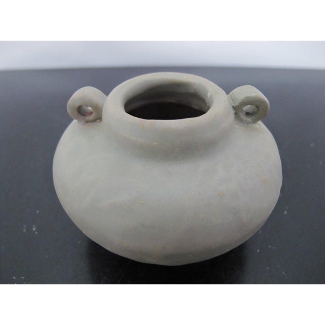 Chinese Longquan celadon glazed jarlet. It features a globular body, two loop handles, and is covered in a characteristic...