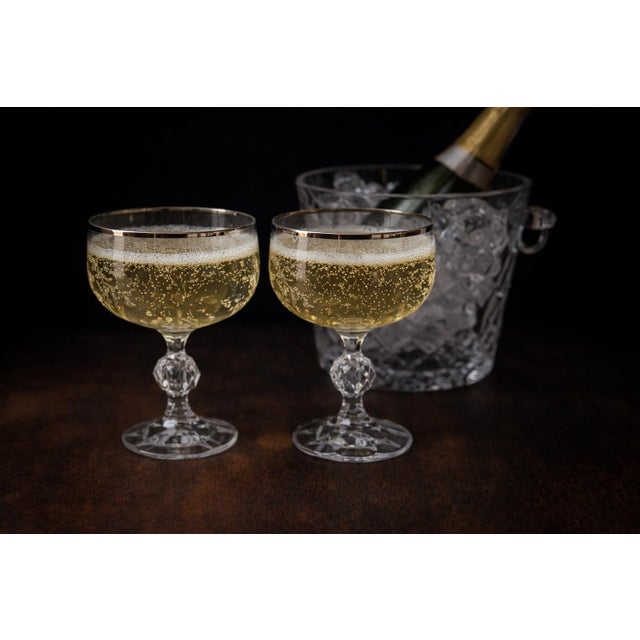 An elegant pair of vintage crystal champagne coupes featuring an elegant etched floral motif, luminous platinum rims, and...