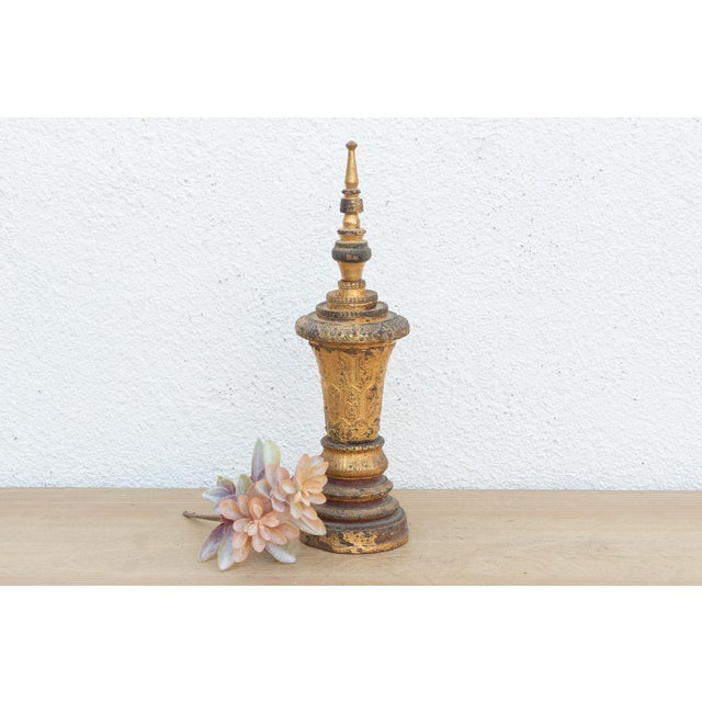 A relic of devotional art from Myanmar, this slender, towering object mimics the form of a Buddhist stupa or the ornate...