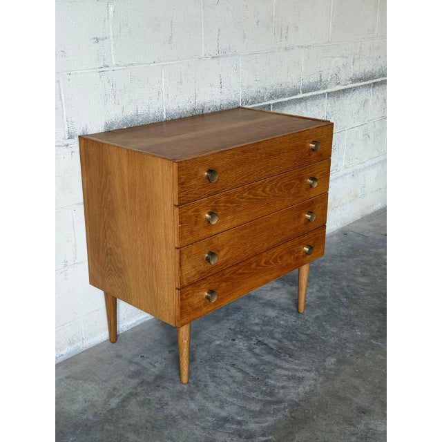 This classic oak dresser features four spacious drawers and clean architectural lines. Elevated on slender tapered legs,...