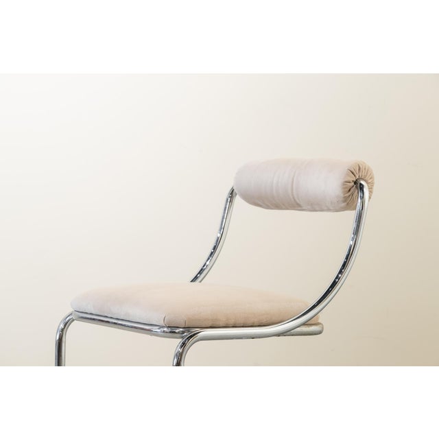 Set of four chairs with a tubular steel frame and white suede upholstery, featuring a cantilever or free-hanging design,...