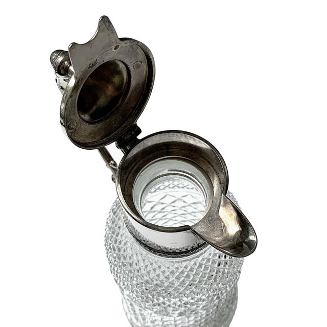 A striking late-19th/early-20th century pressed-glass claret jug with silverplate mount. The sparkling diamond-point glass...