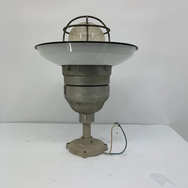 Step back in time and embark on a maritime journey with this vintage Russell & Stoll caged enamel cover boat light....