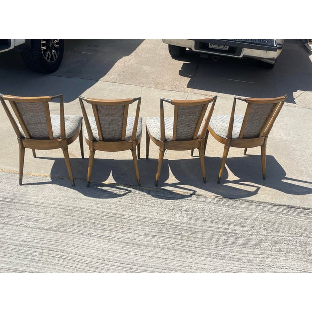 Elegant set of four cherrywood caned back dining chairs with brass sabots and brass crest rail. All of the metal pieces...