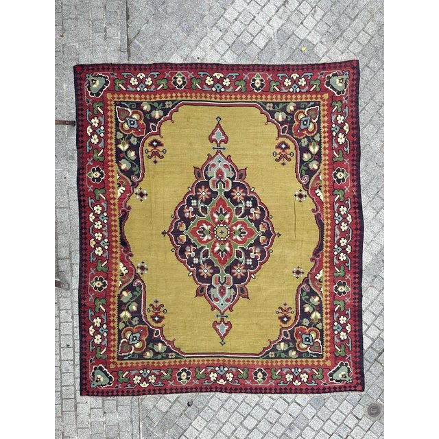 A beautiful mid-century large Kilim featuring a stunning Turkish Oushak rug design with vibrant colors. This piece is...